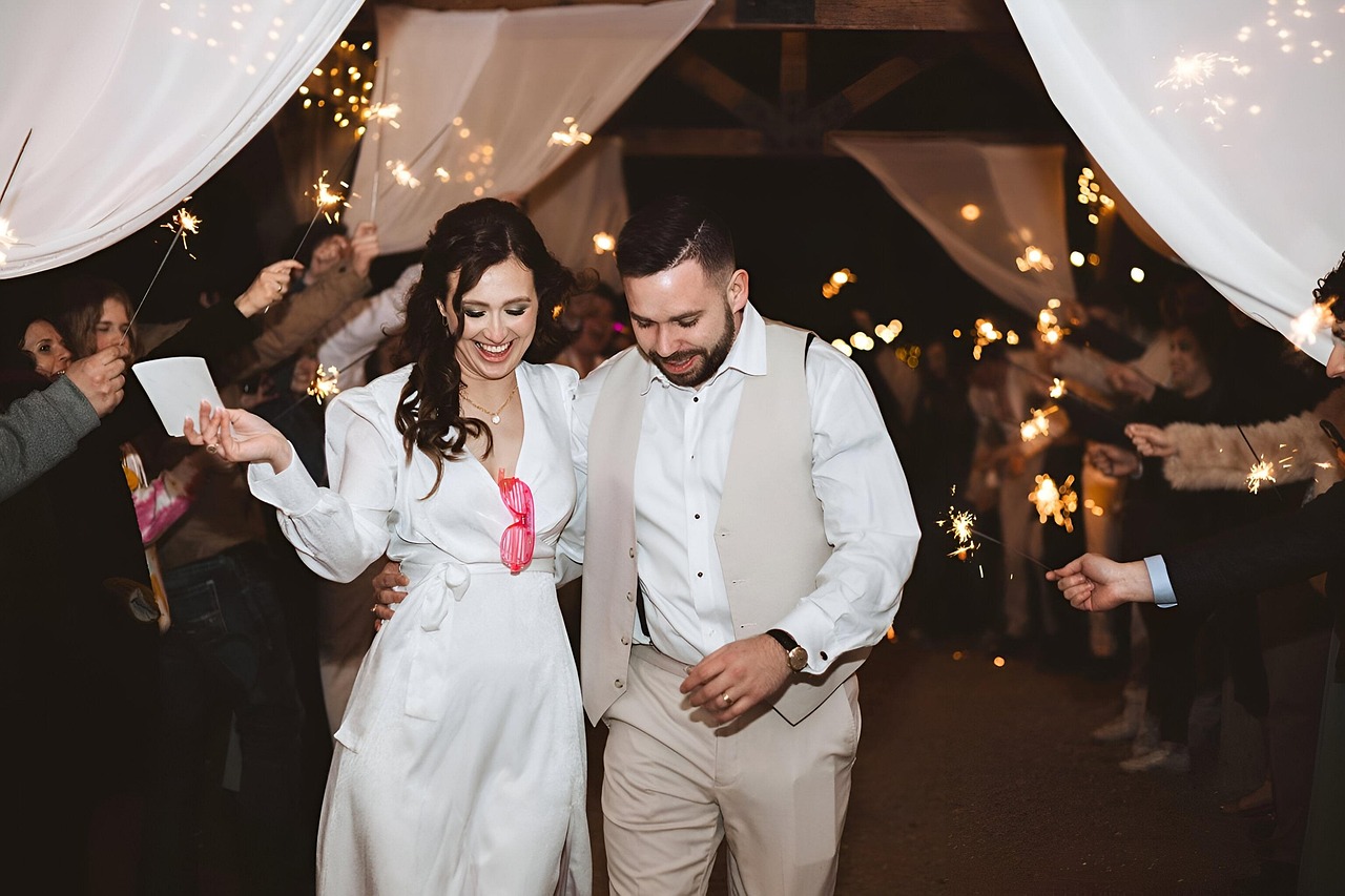 Ein Hochzeitspaar feiert mit seinen Gästen unter Wunderkerzen